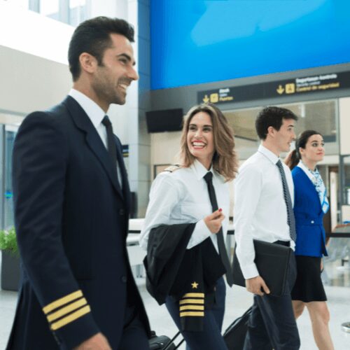 Airline pilots and flight attendants walking through an airport terminal.