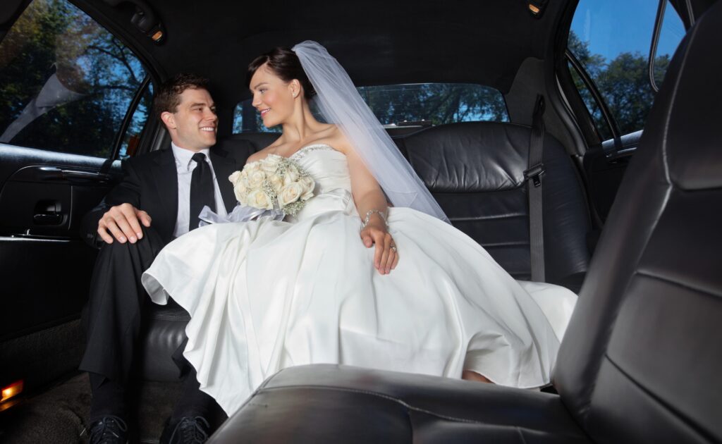 Bride and groom sharing a joyful moment in a limousine.