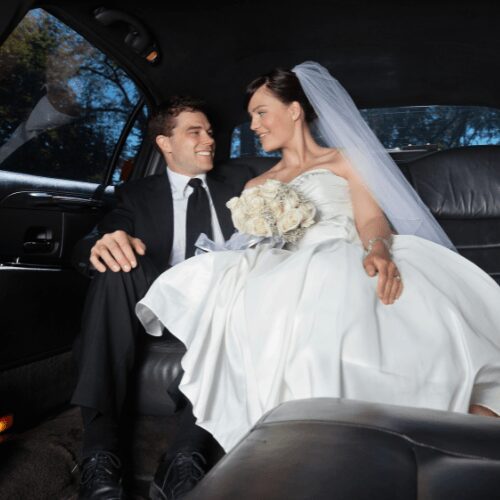 Newlywed couple sharing a moment inside a limousine.
