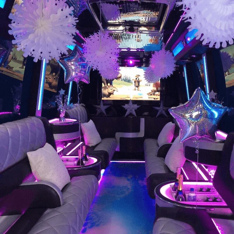 Luxurious party bus interior with vibrant lighting and comfortable seating.