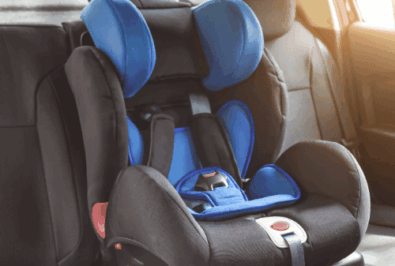 A black and blue child car seat installed in a vehicle's back seat.