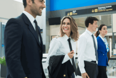 Airline pilots and flight attendants walking through an airport terminal.