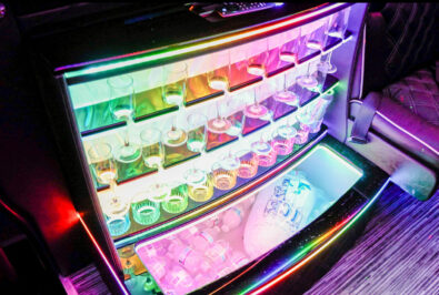Colorfully lit refrigerated display with jars and a glowing drawer.