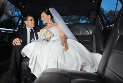 Bride and groom sharing a joyful moment in a limousine.
