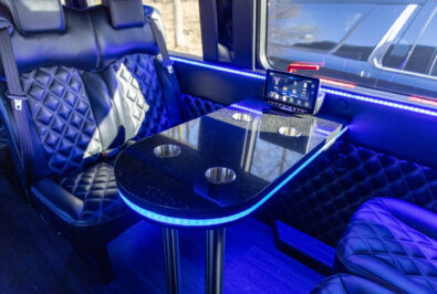 Luxurious car interior with a sleek black table and blue ambient lighting.
