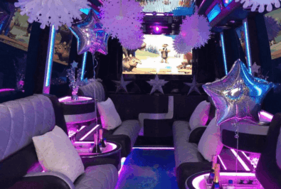 Luxurious party bus interior with vibrant lighting and comfortable seating.